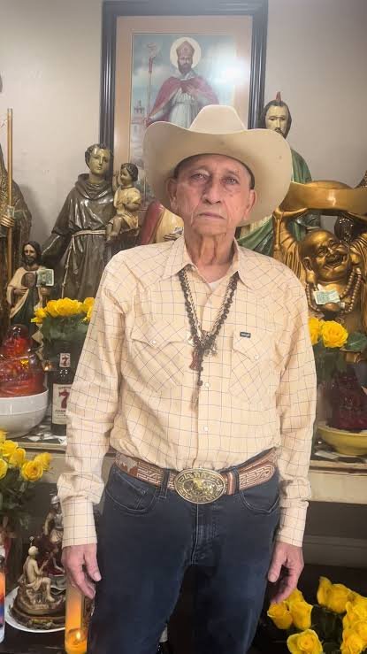 Óscar Interiano con sombrero claro, rodeado de imágenes y flores